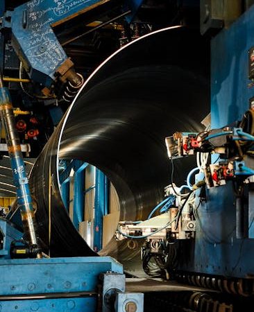 Close-up of a large industrial machine at work in a metal fabrication setting.