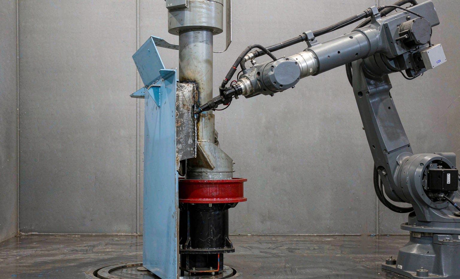 Rotary positioner turning a welded assembly under a robot