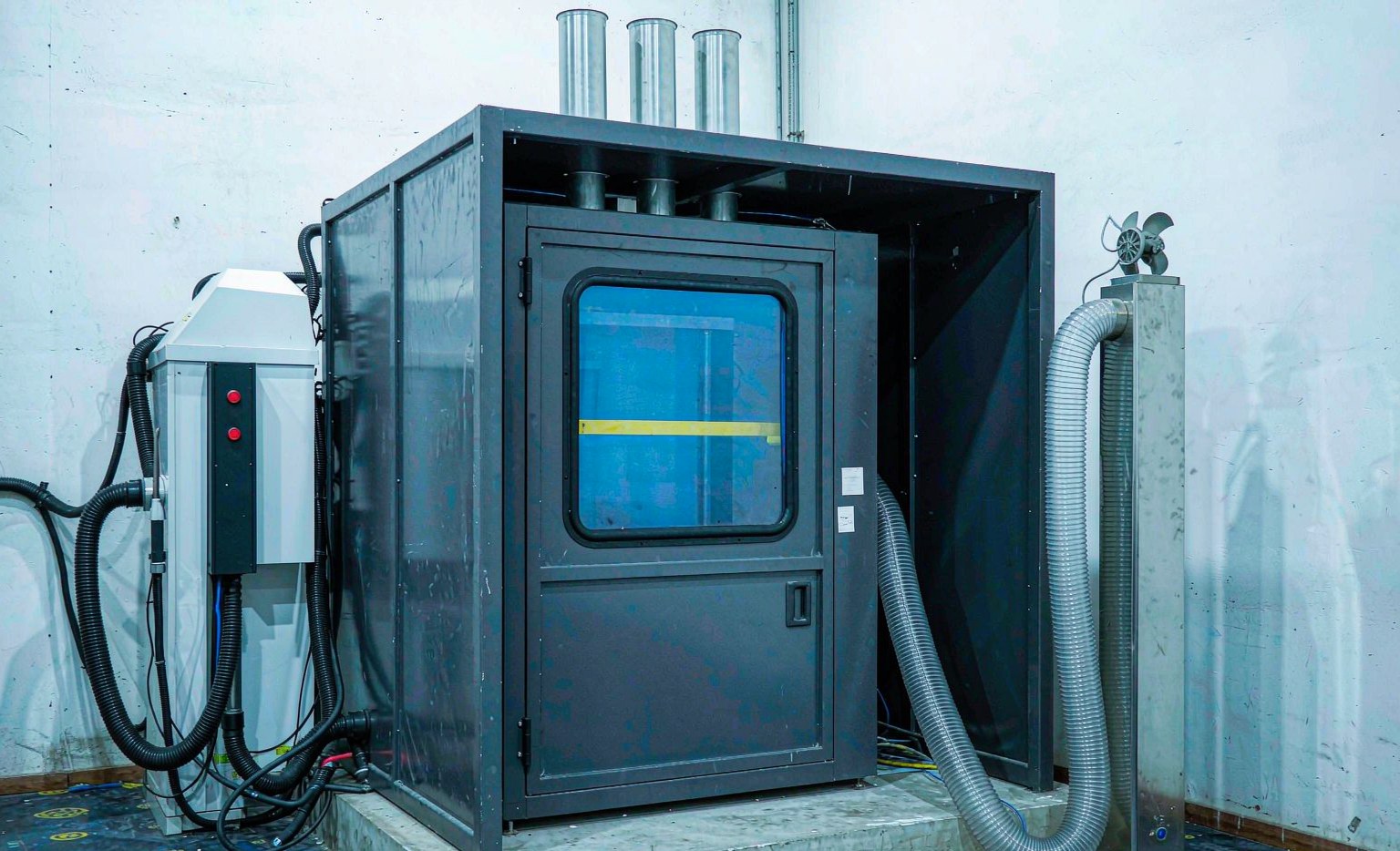 Laser welding cell with enclosed cabin and fume extraction