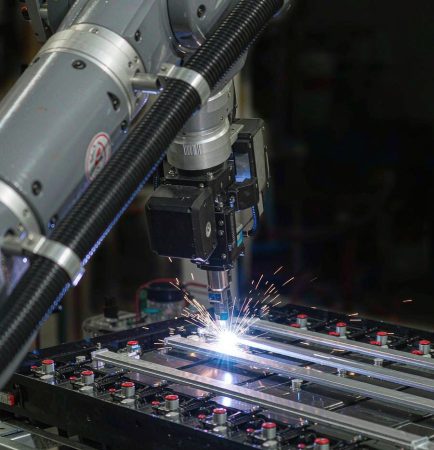 Industrial robot laser welding busbars on an EV battery module
