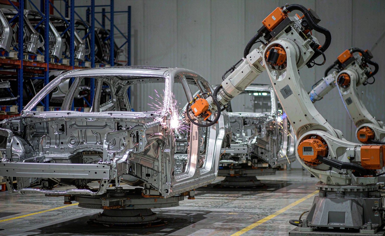 Brazo de soldadura robótica por láser soldando un bastidor de carrocería en una línea de producción automotriz
