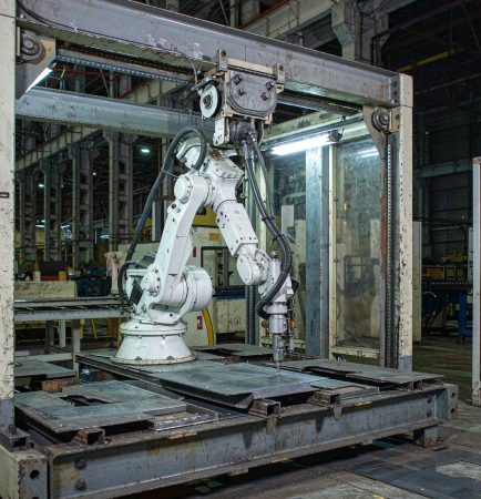 Celda automatizada de procesamiento láser con brazo robótico en una instalación de fabricación metálica