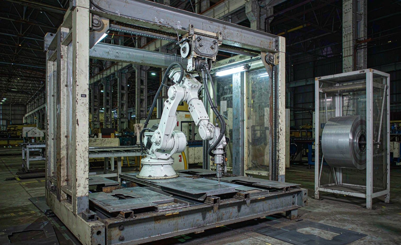 Celda automatizada de procesamiento láser con brazo robótico en una instalación de fabricación metálica