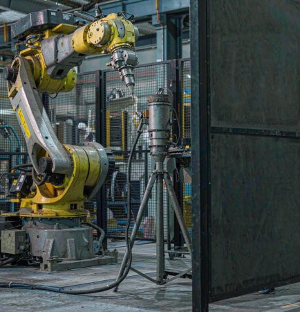 Brazo robótico industrial de soldadura de seis ejes en una celda de soldadura láser