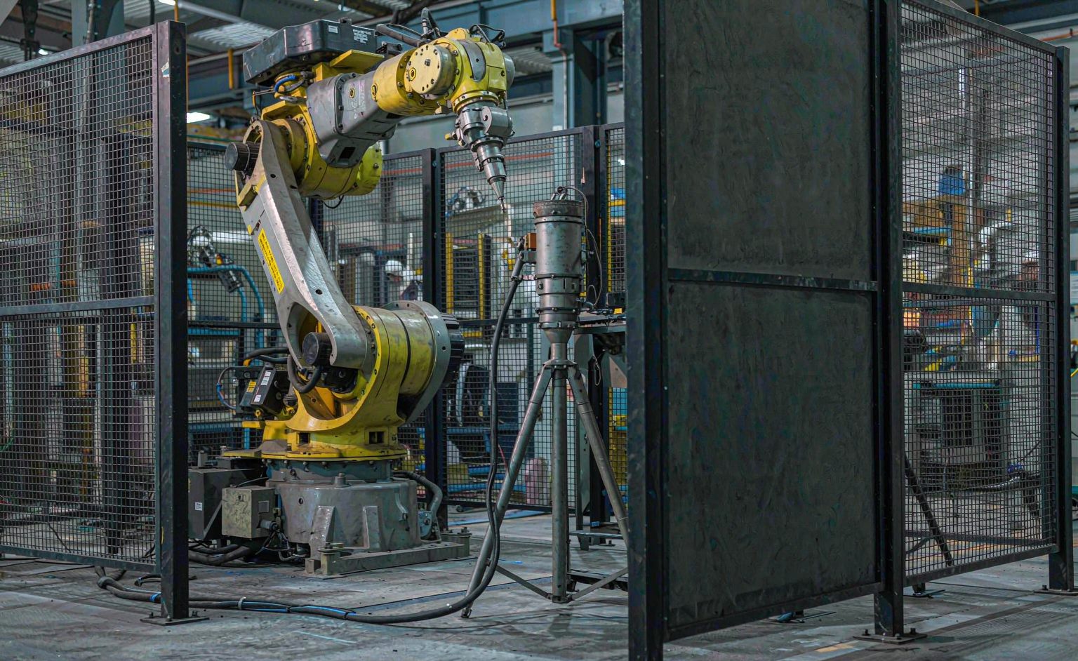 Brazo robótico industrial de soldadura de seis ejes en una celda de soldadura láser